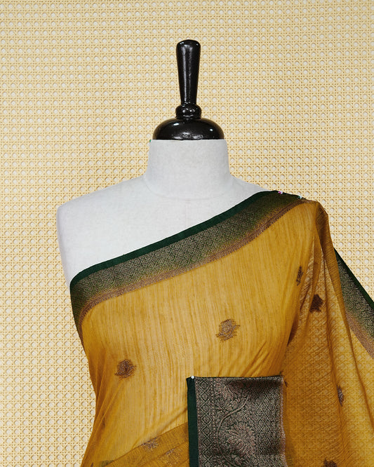 Mustard yellow colour semi linen saree thread motifs on body, contrast bottle green colour gold zari border, rich pallu comes with matching blouse piece