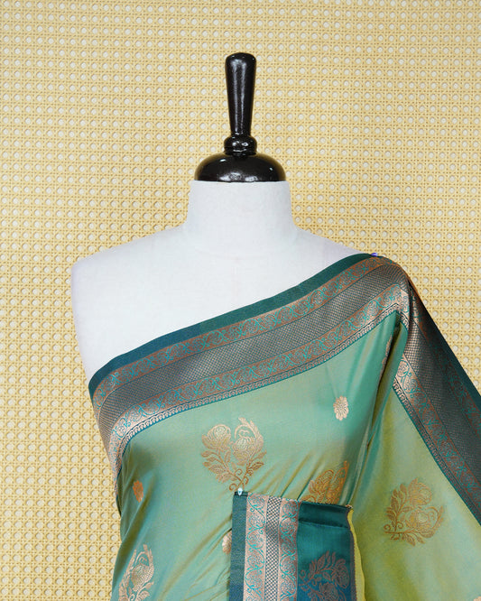 Olive green & gold double shade Mulberry silk saree featuring floral gold zari patterns on body, paired with contrast teal colour with traditional border, comes with matching blouse piece.