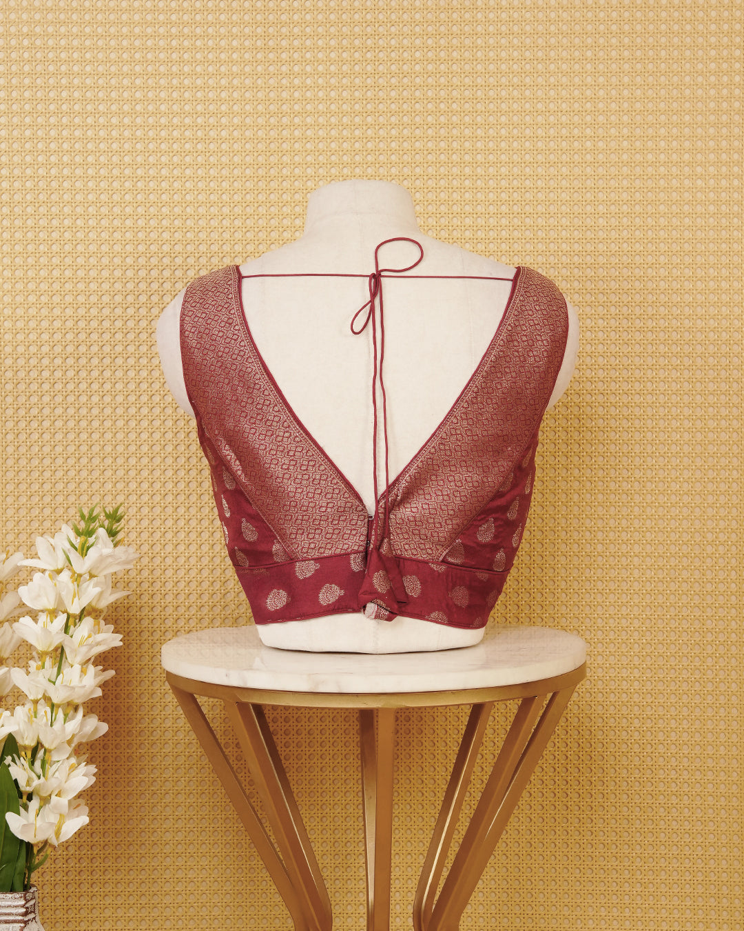 Chocolate colour Sleeveless Blouse Featuring A Stylish V-Neck, Elegant Woven Pattern With Gold Butta Motifs, And A Comfortable Tailored Fit.