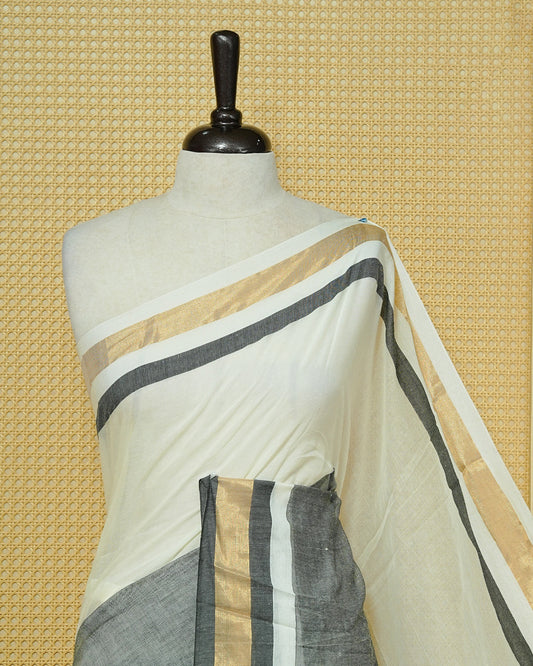 White  Colour Mul Cotton Saree featuring a grey and gold zari border with a matching grey pallu, finished with black and white tassels.
