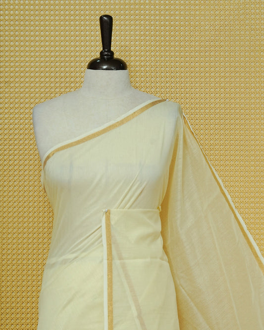 Cream Mul Cotton Saree featuring a graceful plain body with a subtle gold zari border and a finely woven striped pallu. Finished with vibrant red tassels