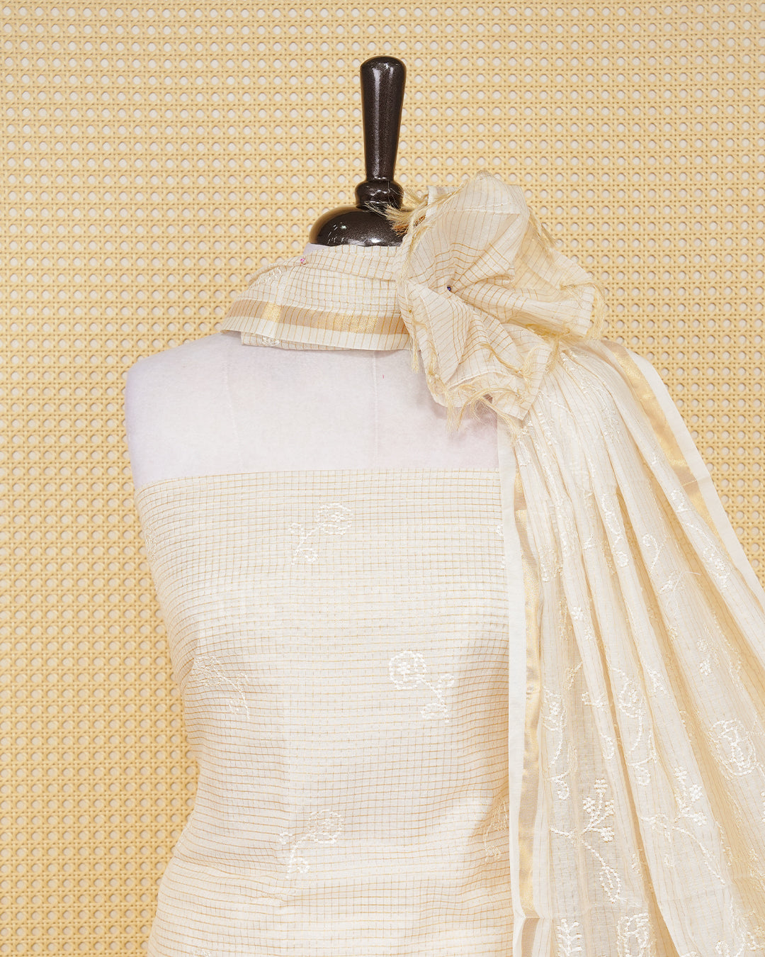 Cream colour tissue salwar material featuring gold zari checked pattern with elegant floral threadwork pattern on the body, paired with a matching bottom and an elegant dupatta.