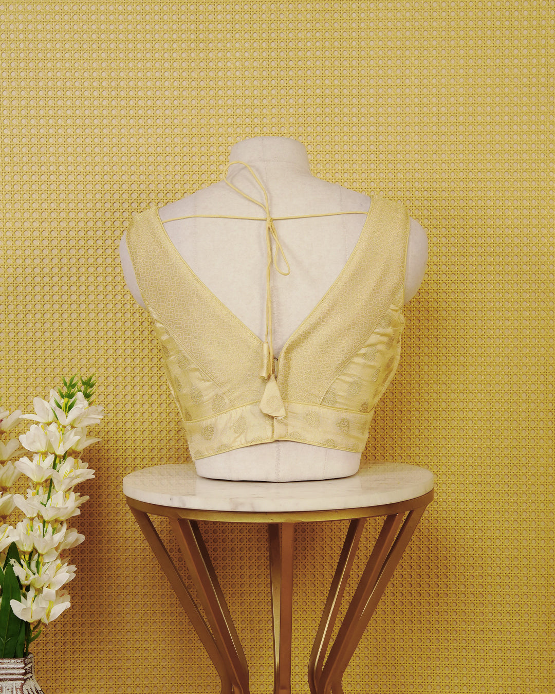 Gold colour Sleeveless Blouse Featuring A Stylish V-Neck, Elegant Woven Pattern With Gold Butta Motifs, And A Comfortable Tailored Fit.