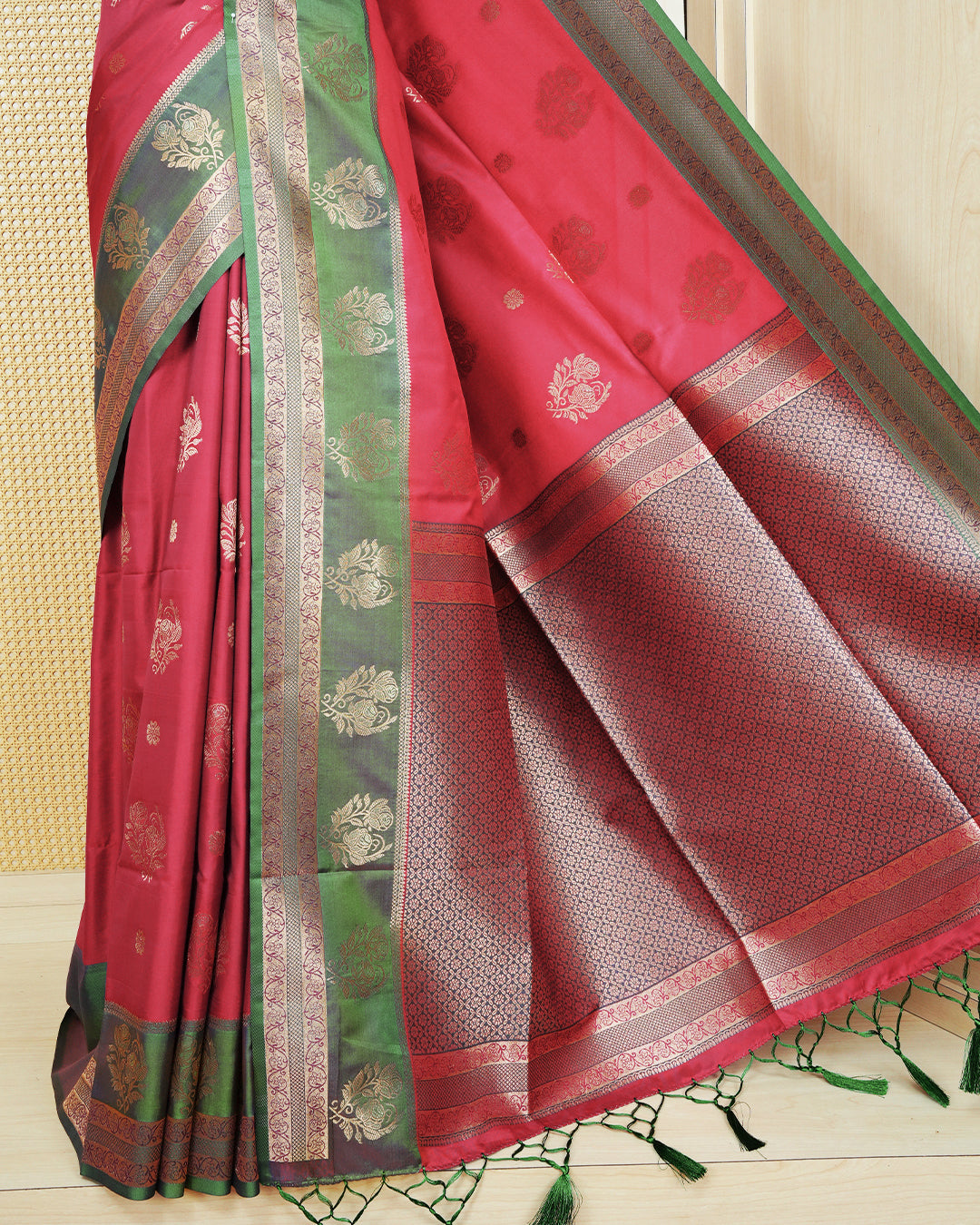 Red colour Mulberry silk saree featuring floral gold zari patterns on body, paired with contrast Green colour with traditional border, comes with matching blouse piece.