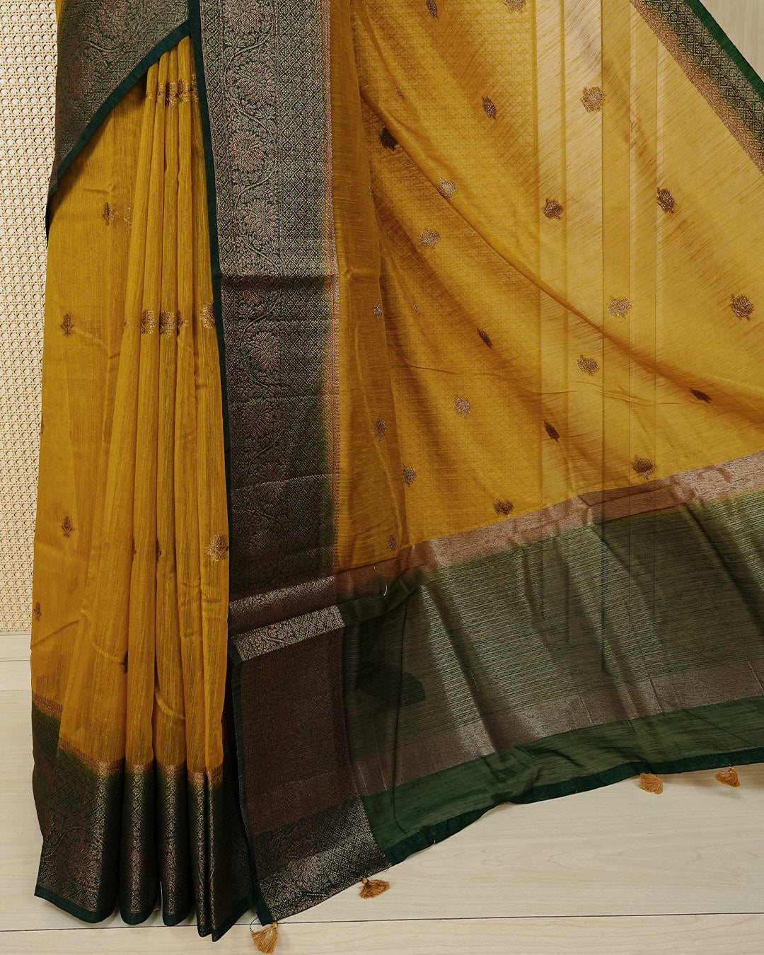 Mustard yellow colour semi linen saree thread motifs on body, contrast bottle green colour gold zari border, rich pallu comes with matching blouse piece
