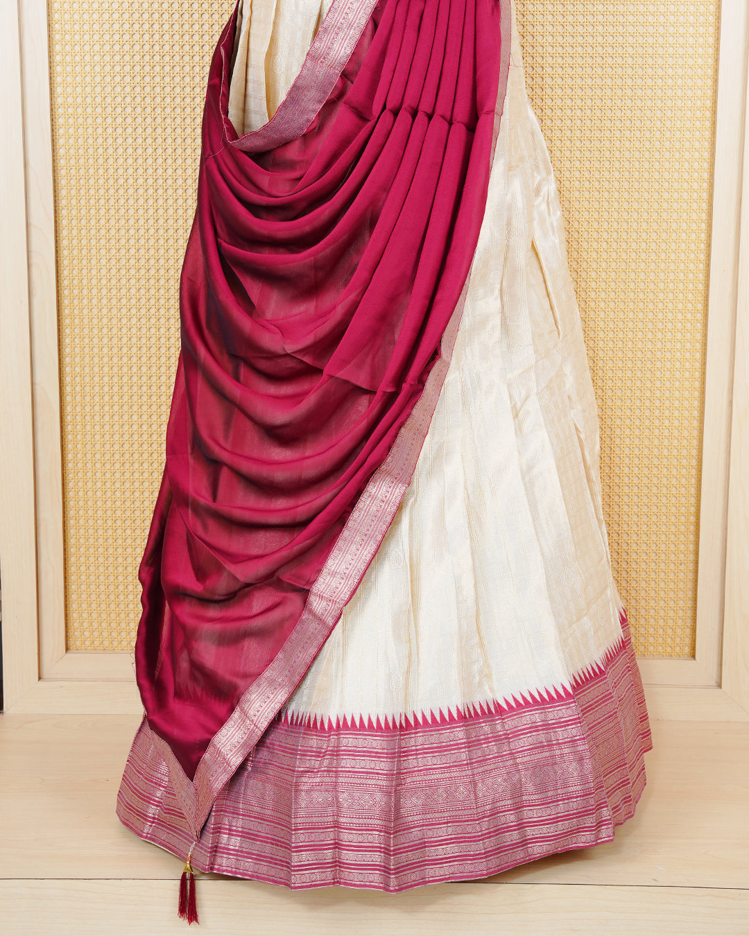 Cream colour  tissue Semi stitched dhavani set featuring Gold zari check pattern with motifs on body ,contrast Brick Red colour with gold zari bordered skirt, paired with matching blouse piece & dupatta.