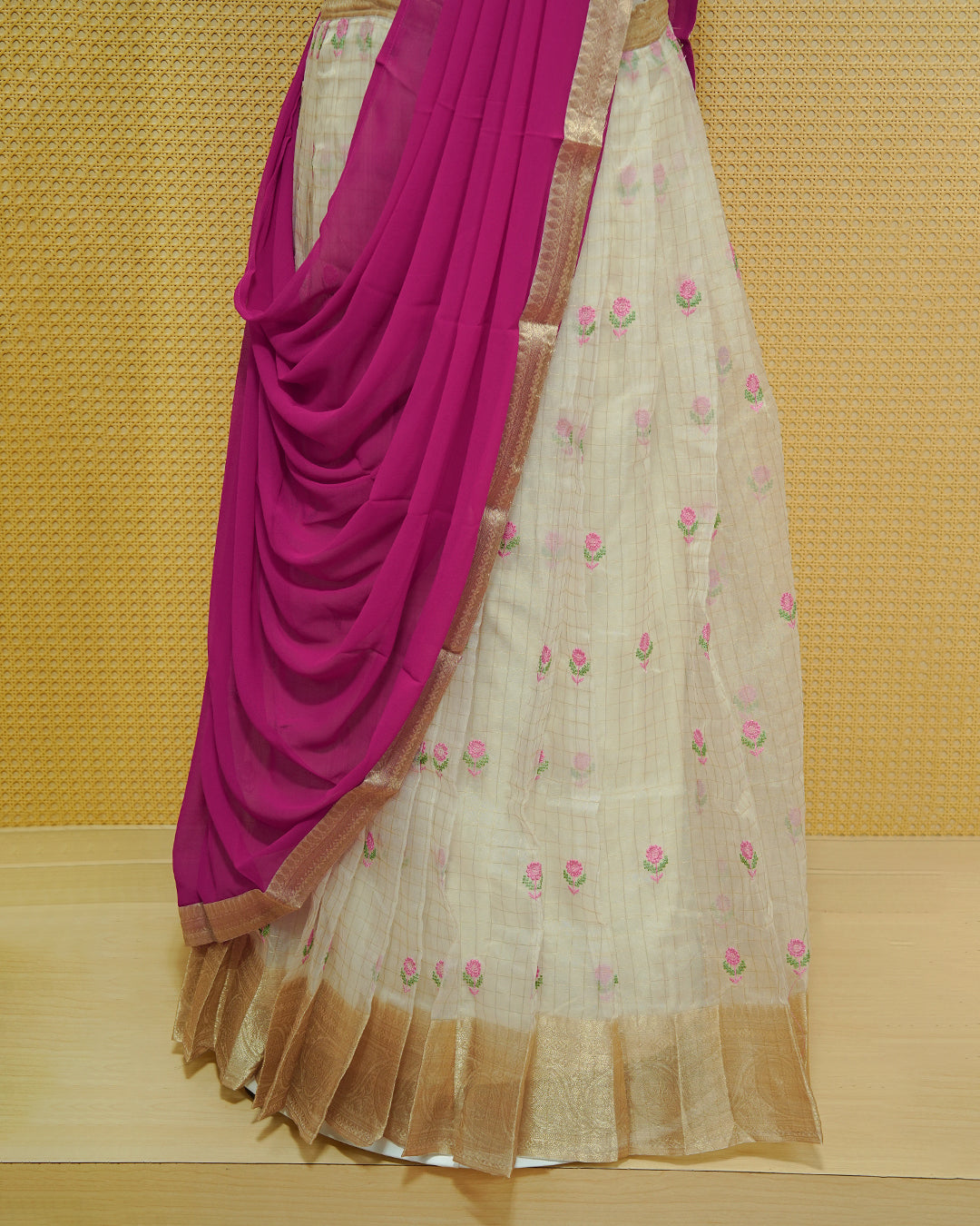 Cream colour Semi stitched Dhavani set featuring Gold zari checked pattern with floral motifs on skirt with traditional border, comes with contrast Colour Dupatta & matching blouse piece.