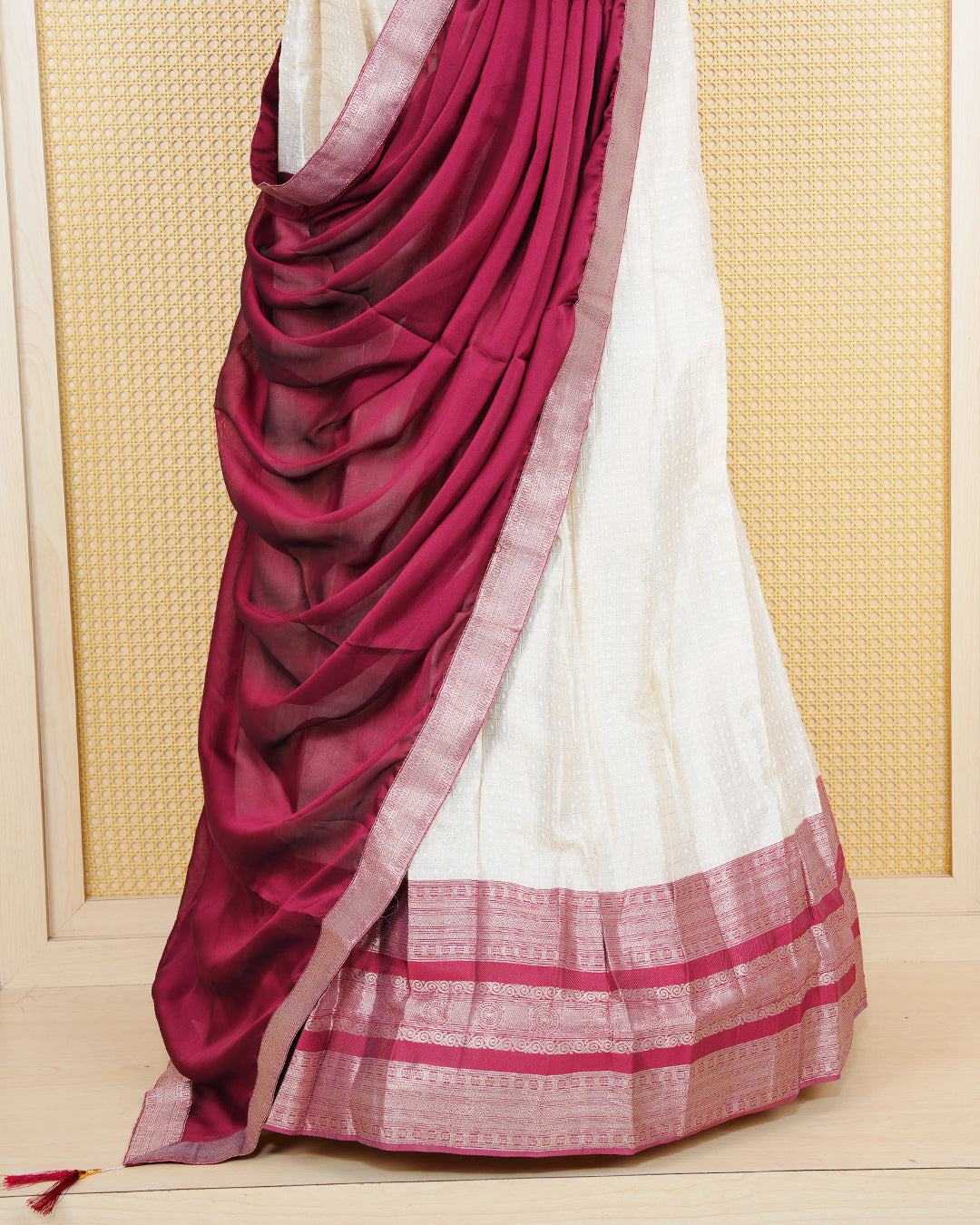 Cream colour  tissue  Semi stitched dhavani set featuring Gold zari check pattern with motifs on body ,contrast Brick Red colour with gold zari bordered skirt, paired with matching blouse piece & dupatta.