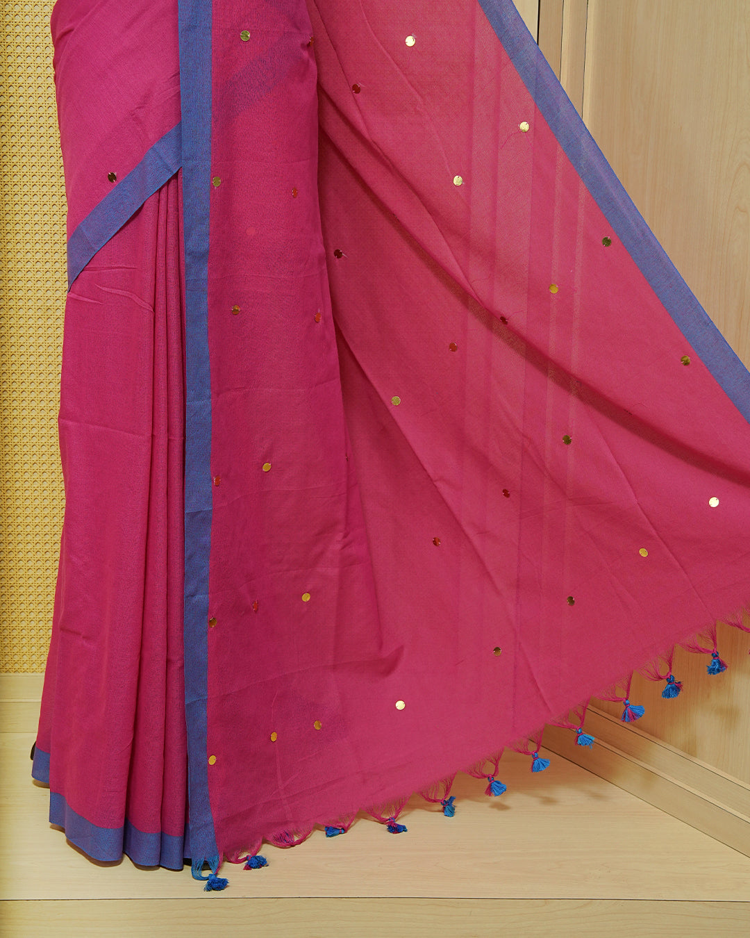 Magenta colour Mul cotton saree featuring Gold Sequins, complemented by Contrast Blue simple Border & tassels.
