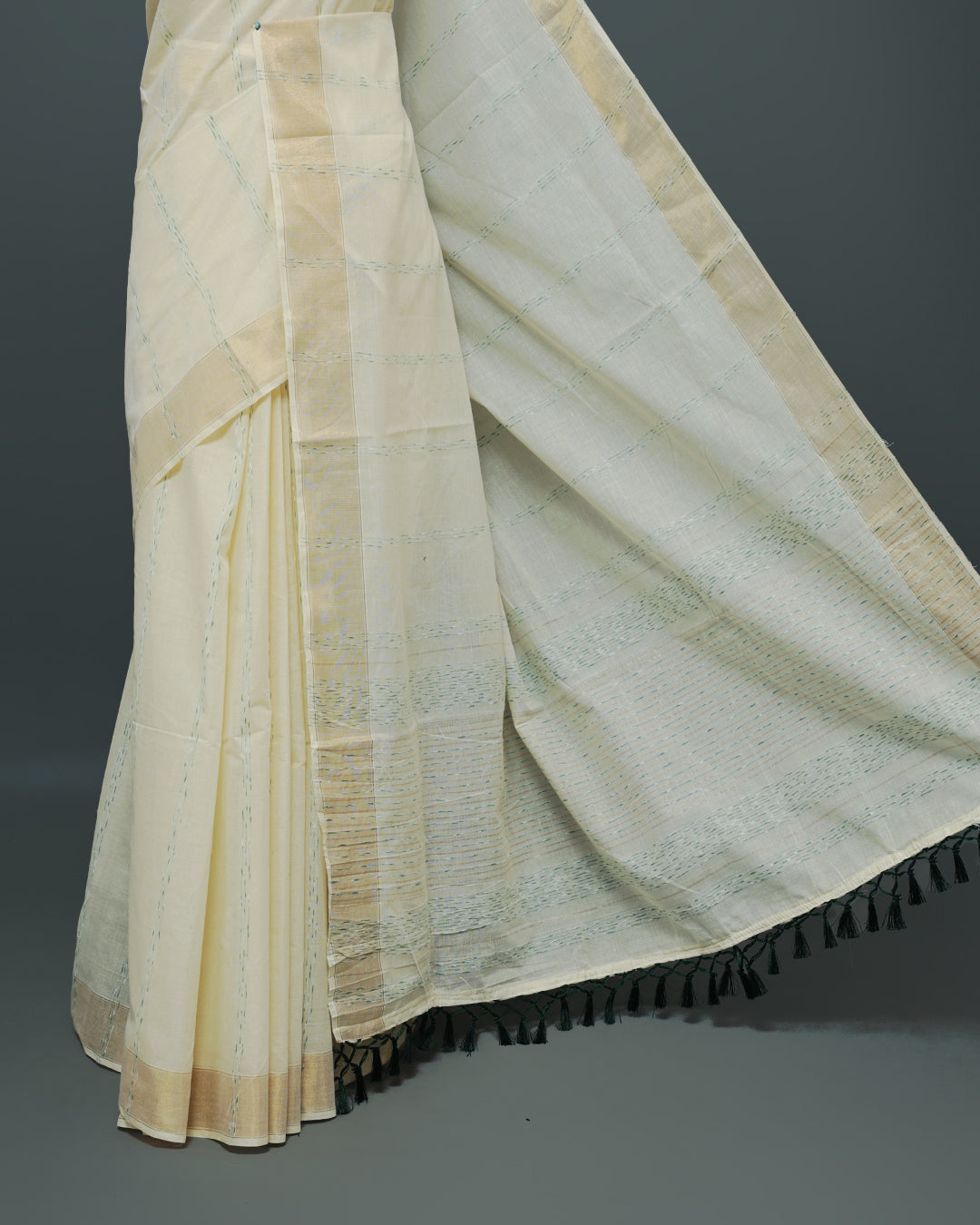 Cream colour Cotton kerala saree featuring Green & gold Strips on body, complemented by Gold zari Border, paired with matching blouse piece.