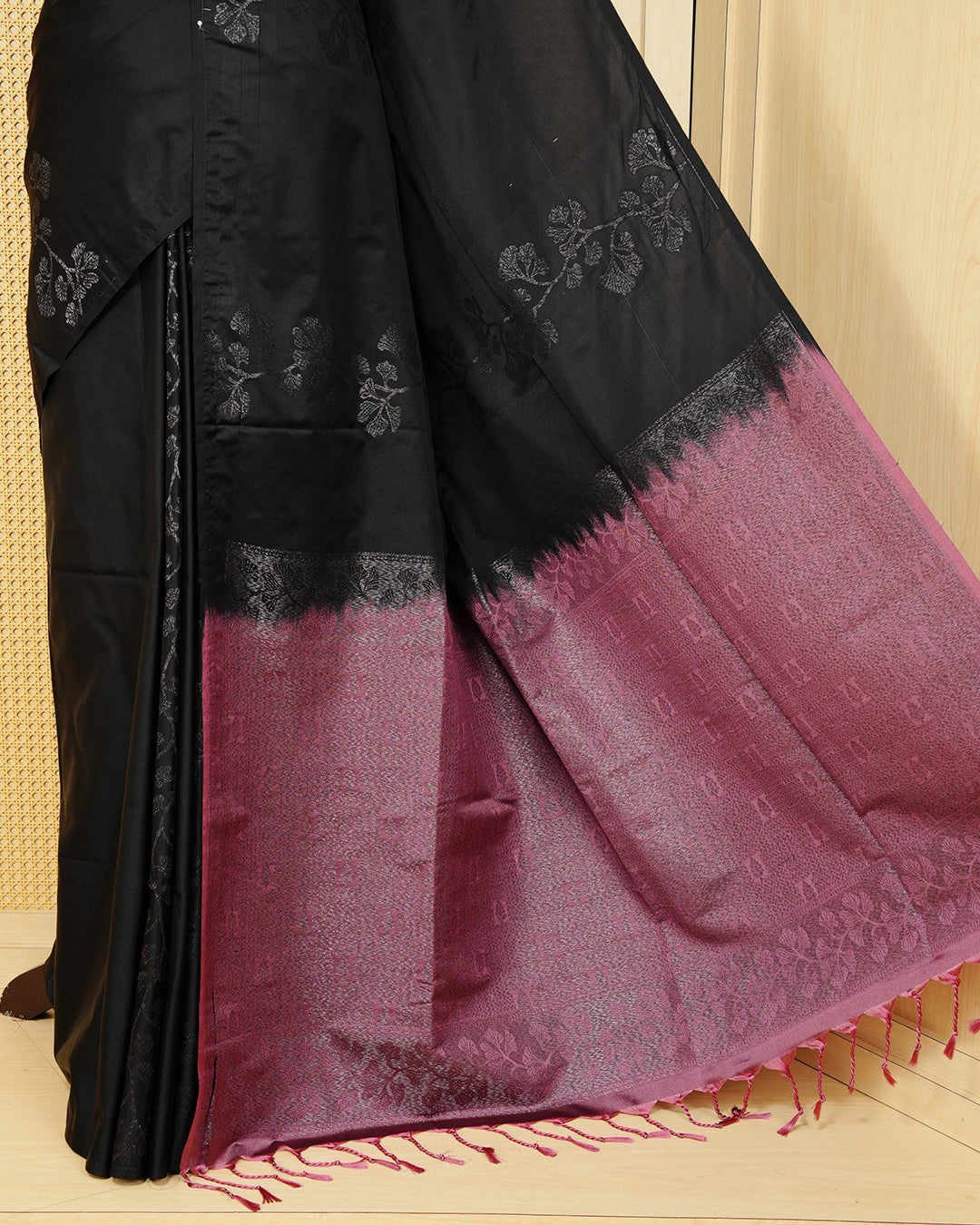 Black colour soft silk saree featuring antique zari motifs on body with contrast dusty rose colour pallu & paired with matching blouse piece.