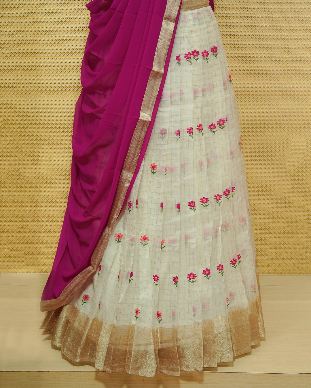 Cream colour Semi stitched Dhavani set featuring Gold zari checked pattern with floral motifs on skirt with traditional border, comes with contrast Colour Dupatta & matching blouse piece.