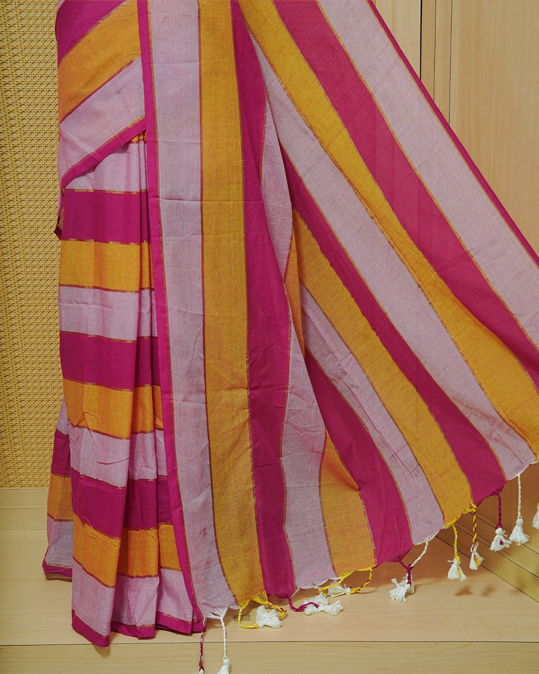 Pink & Mustard  Colour Mul Cotton Saree featuring bold striped patterns in Magenta, mustard, and soft pink, accented with subtle zari lines and finished with white tassels.