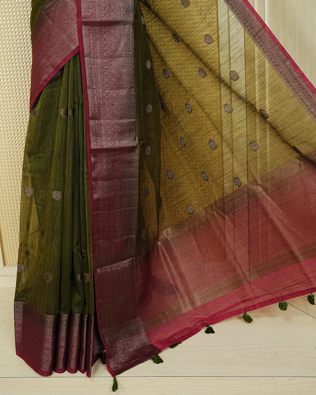 Dark olive colour semi linen saree thread motifs on body, contrast wine colour gold zari border, rich pallu comes with matching blouse piece