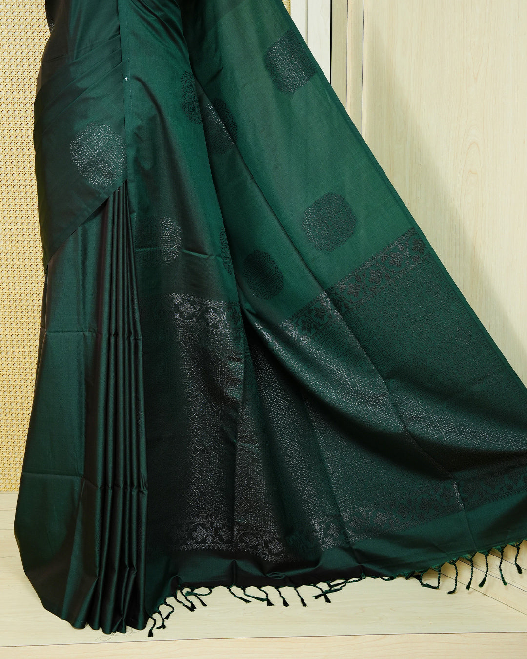 Dark forest green colour soft silk saree featuring antique zari motifs on body with contrast self colour pallu & paired with matching blouse piece.