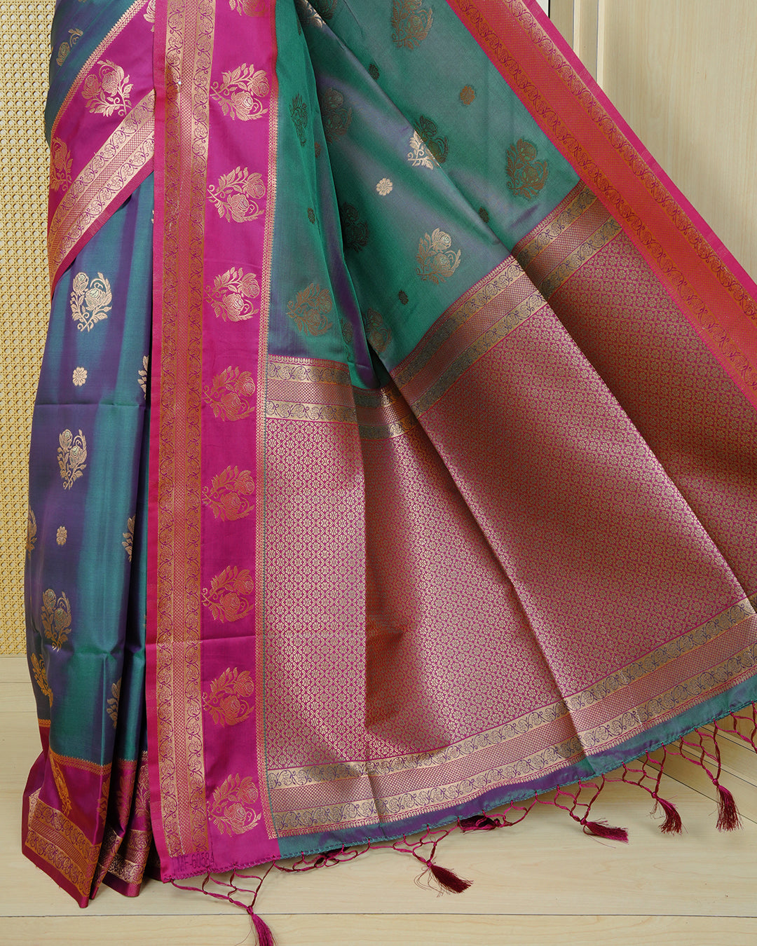 Green colour Mulberry silk saree featuring gold floral zari patterns on body, paired with contrast magenta colour with traditional border, comes with matching blouse piece.