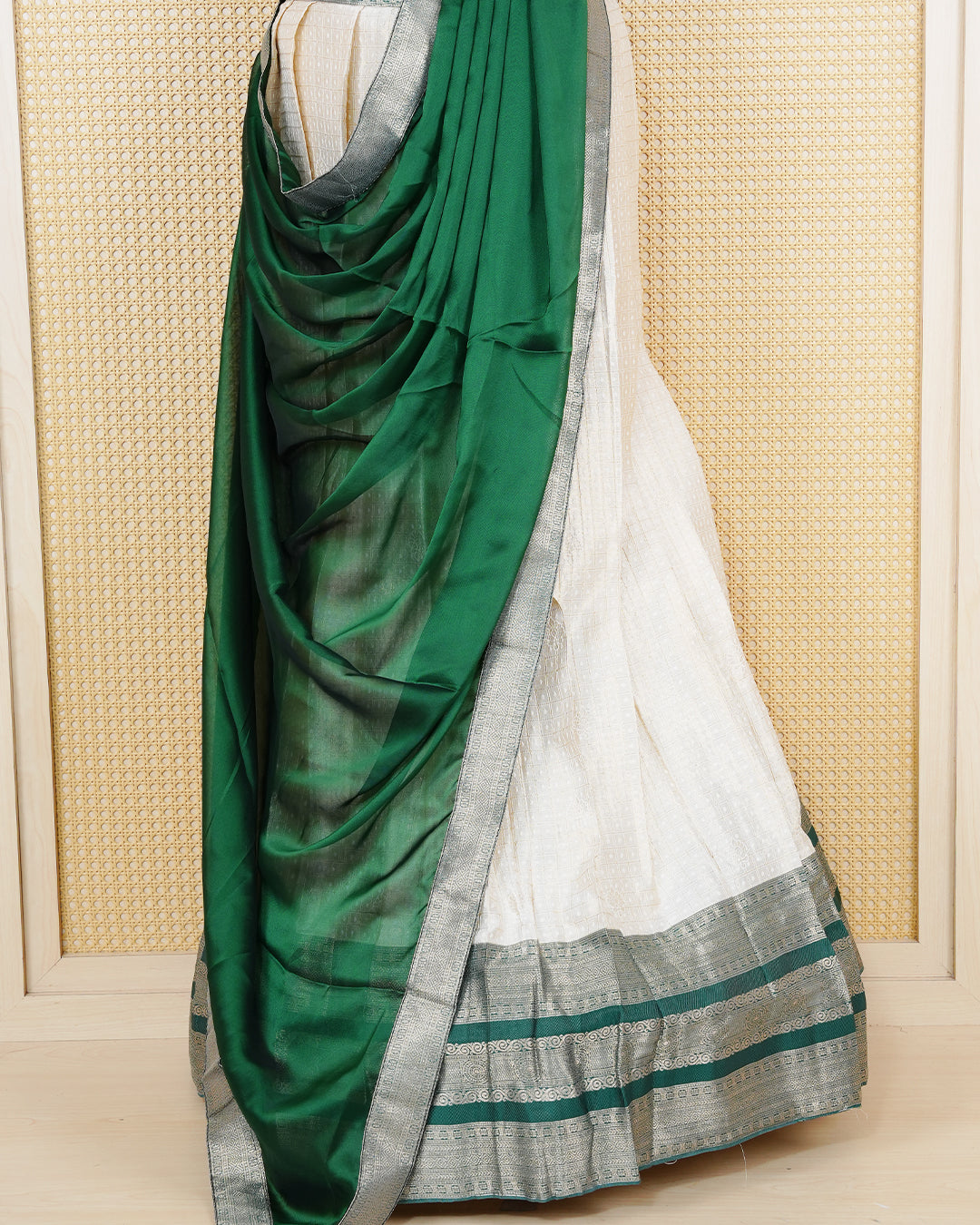 Cream colour  tissue Semi stitched dhavani set featuring Gold zari check pattern with motifs on body ,contrast Green colour with gold zari bordered skirt, paired with matching blouse piece & dupatta.