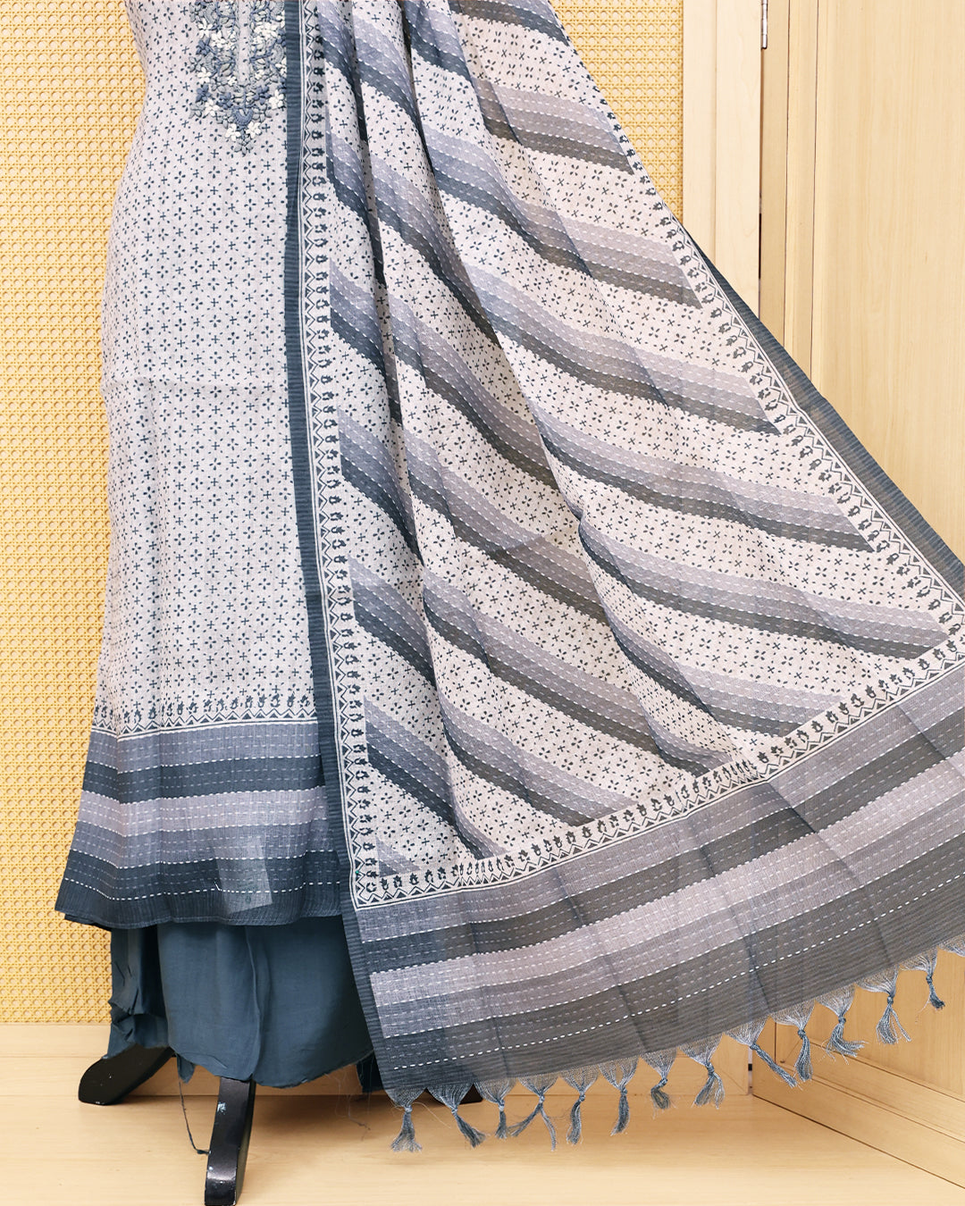 Cream colour Linen Salwar Material with  Printed body ,delicate floral embroidery on yoke, paired with a solid slate grey bottom and a beautifully striped printed dupatta with tassel detailing