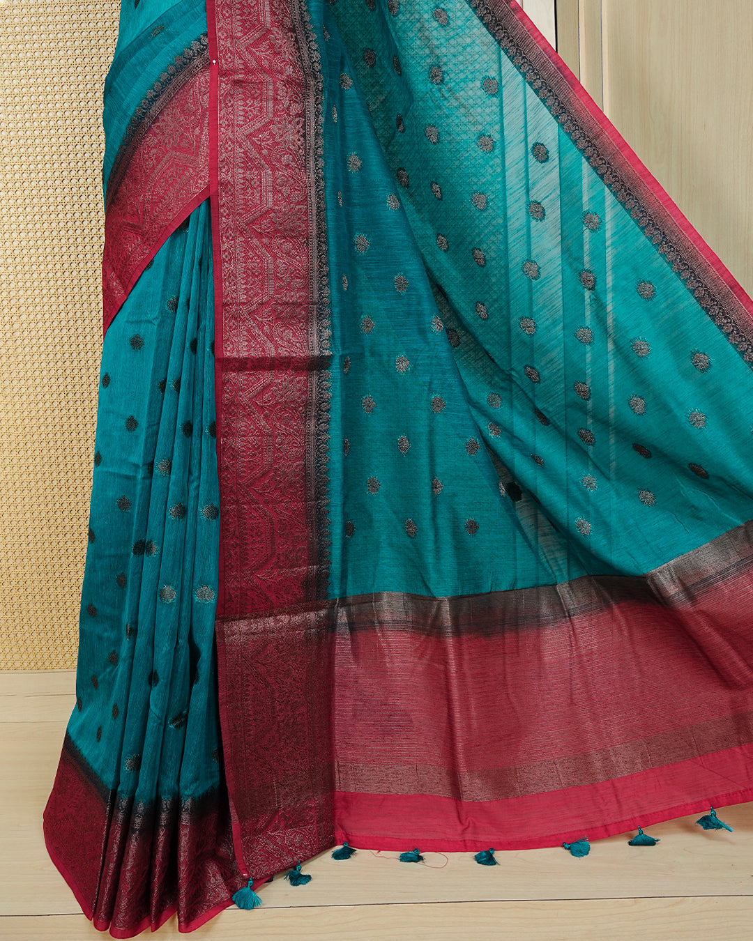 Dark teal colour semi linen saree thread motifs on body, contrast dark pink colour gold zari border, rich pallu comes with matching blouse piece