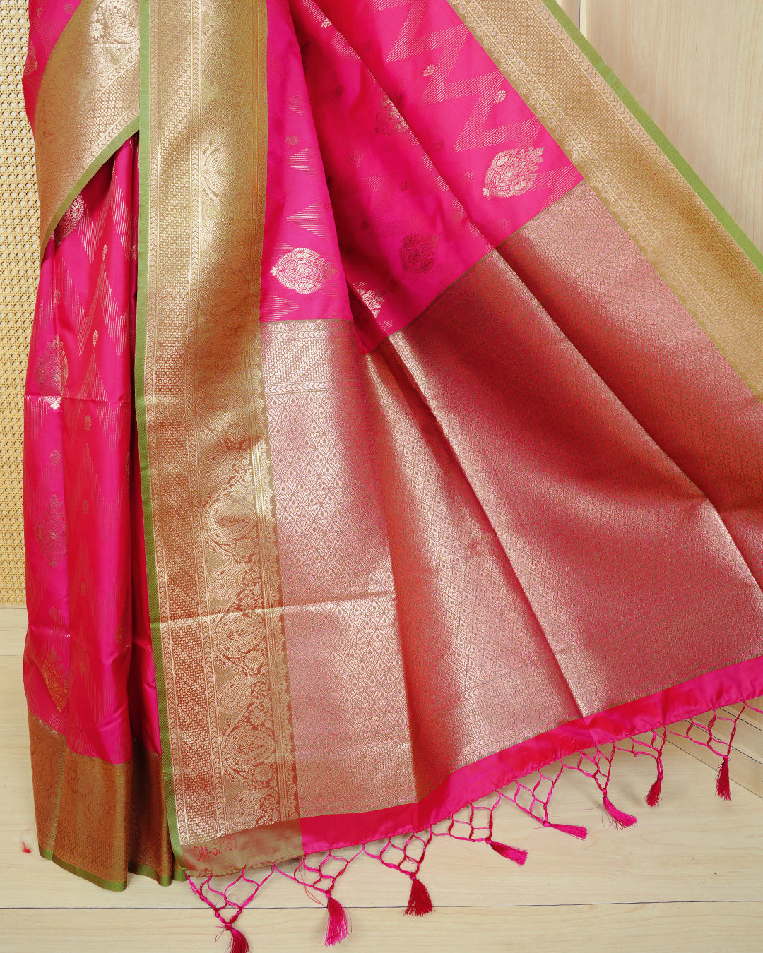 Pink Mulberry silk saree featuring gold floral zari patterns on body, paired with contrast light green colour with traditional border, comes with matching blouse piece.