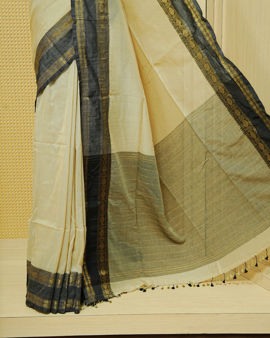 Beige Colour  Mul Cotton Saree featuring an elegant plain body, complemented by a black contrast zari border and matching black tassels