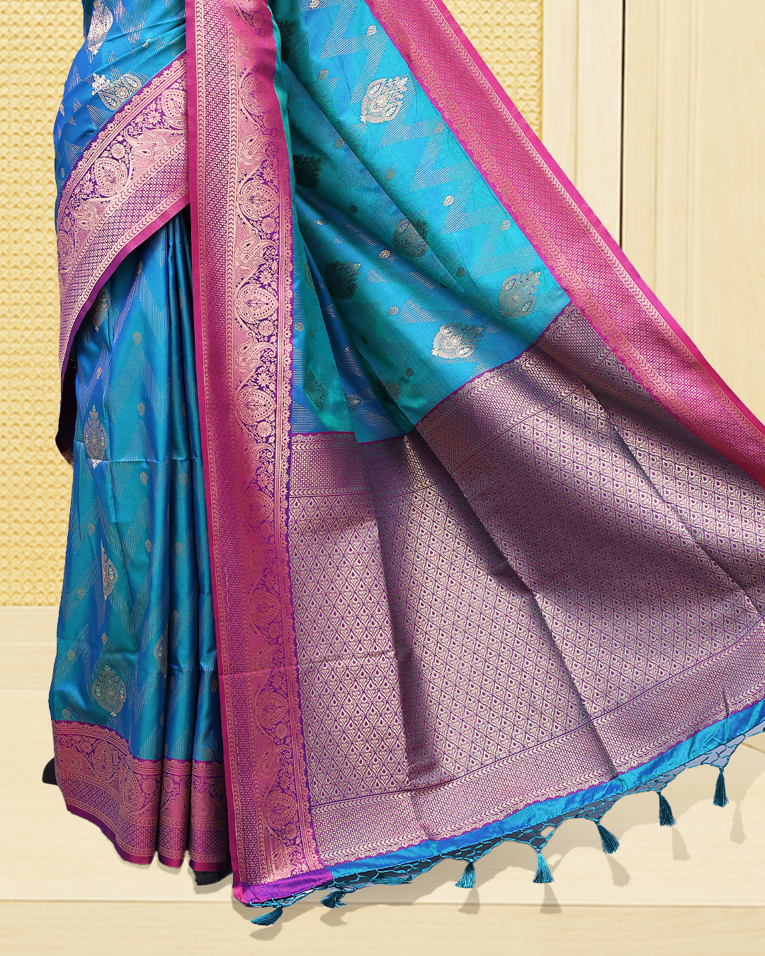 Teal colour Mulberry silk saree featuring floral gold zari patterns on body, paired with contrast Purple colour with traditional border, comes with matching blouse piece.