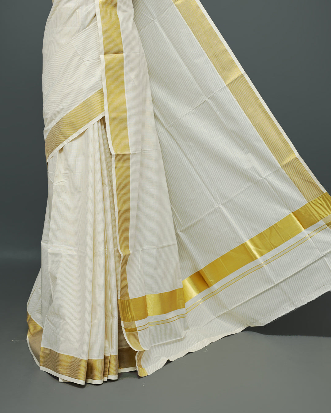 Cream colour Kerala saree Featuring Gold zari stripes on the body, complemented by a classic gold zari border, matching blouse piece.