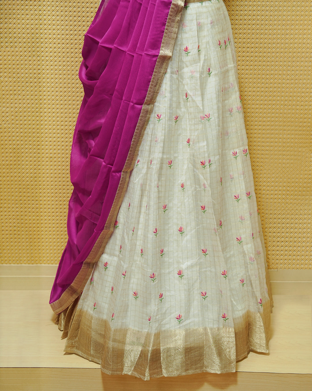 Cream colour Semi stitched Dhavani set featuring Gold zari checked pattern with floral motifs on skirt with traditional border, comes with contrast Colour Dupatta & matching blouse piece.