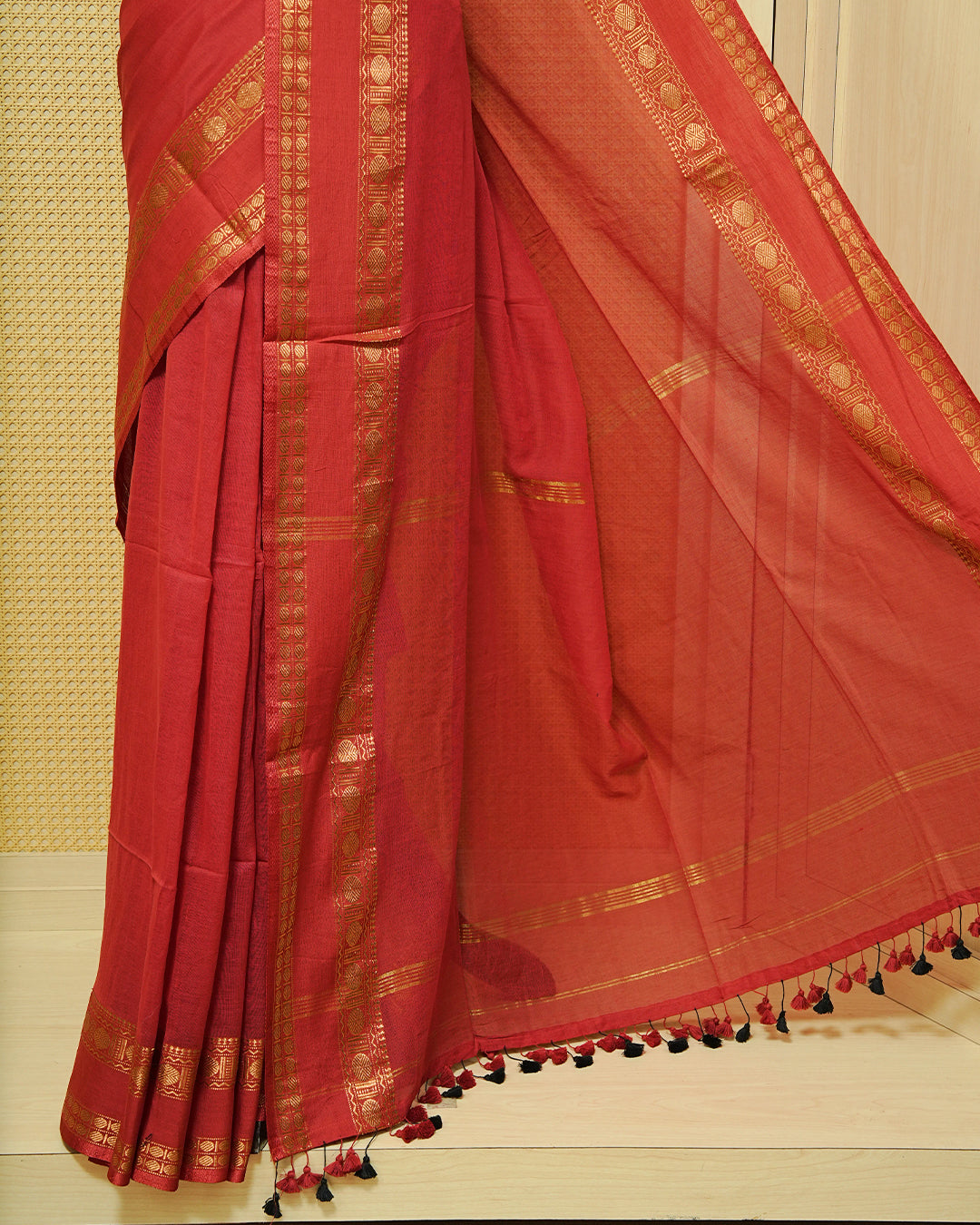 Red colour Mul cotton saree featuring Elegant plain body, complemented by Self colour Gold zari border & tassels.