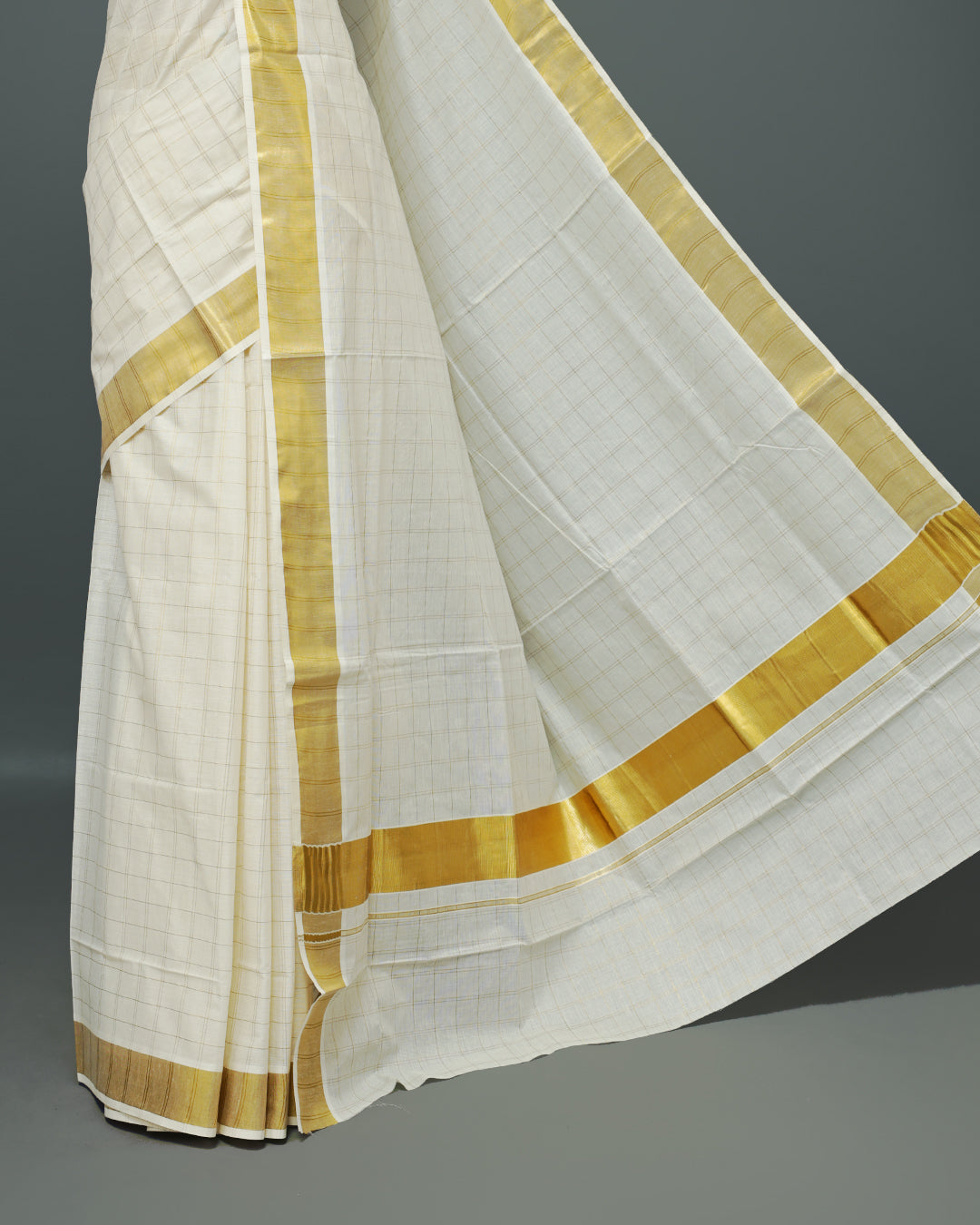 Cream colour Kerala saree Featuring Gold zari Checks on the body, complemented by a classic gold zari border, matching blouse piece.