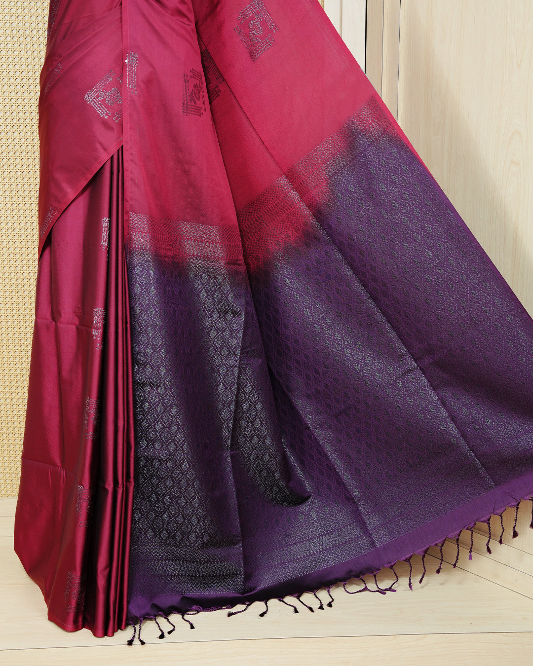 Maroon colour soft silk saree featuring antique zari motifs on body with contrast dark purple colour pallu & paired with matching blouse piece.