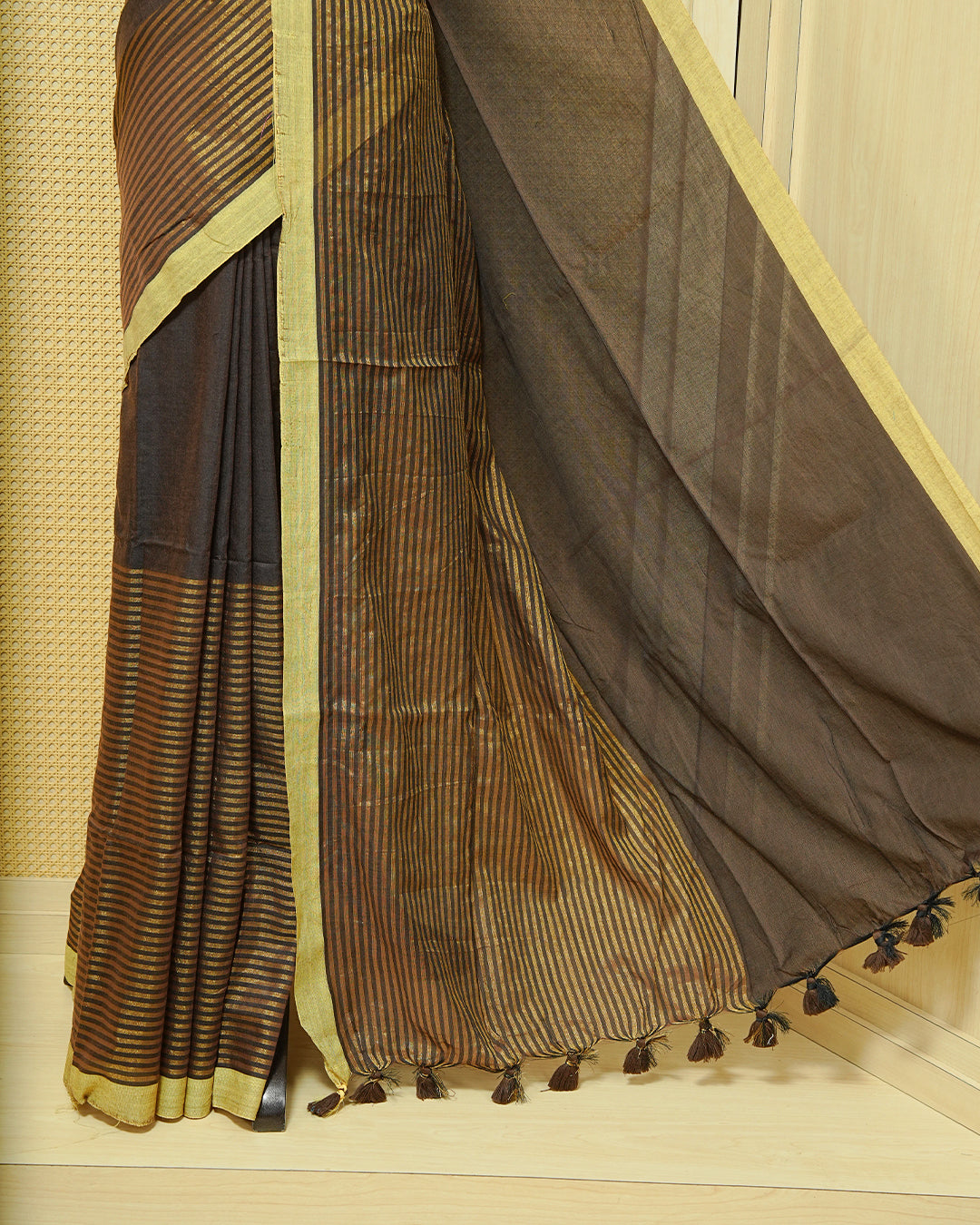 Dark Brown  Colour Mul Cotton Saree with a plain brown body, elegant Olive border, and striped pallu. Finished with a matching tassels