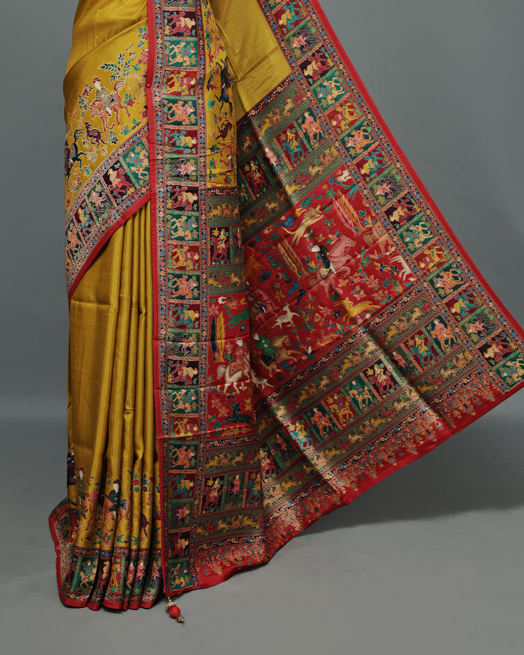 Mustard Colour Pashmina Saree featuring Plain body, complemented by Contrast Red colour with Man With Horse pattern & gold zari on border and Pallu, comes with matching blouse piece.