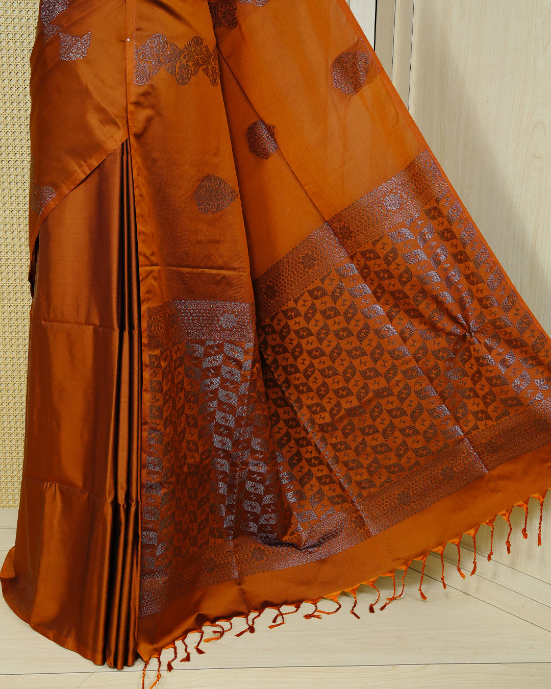 Rust orange colour soft silk saree featuring antique zari motifs on body with contrast self colour pallu & paired with matching blouse piece.