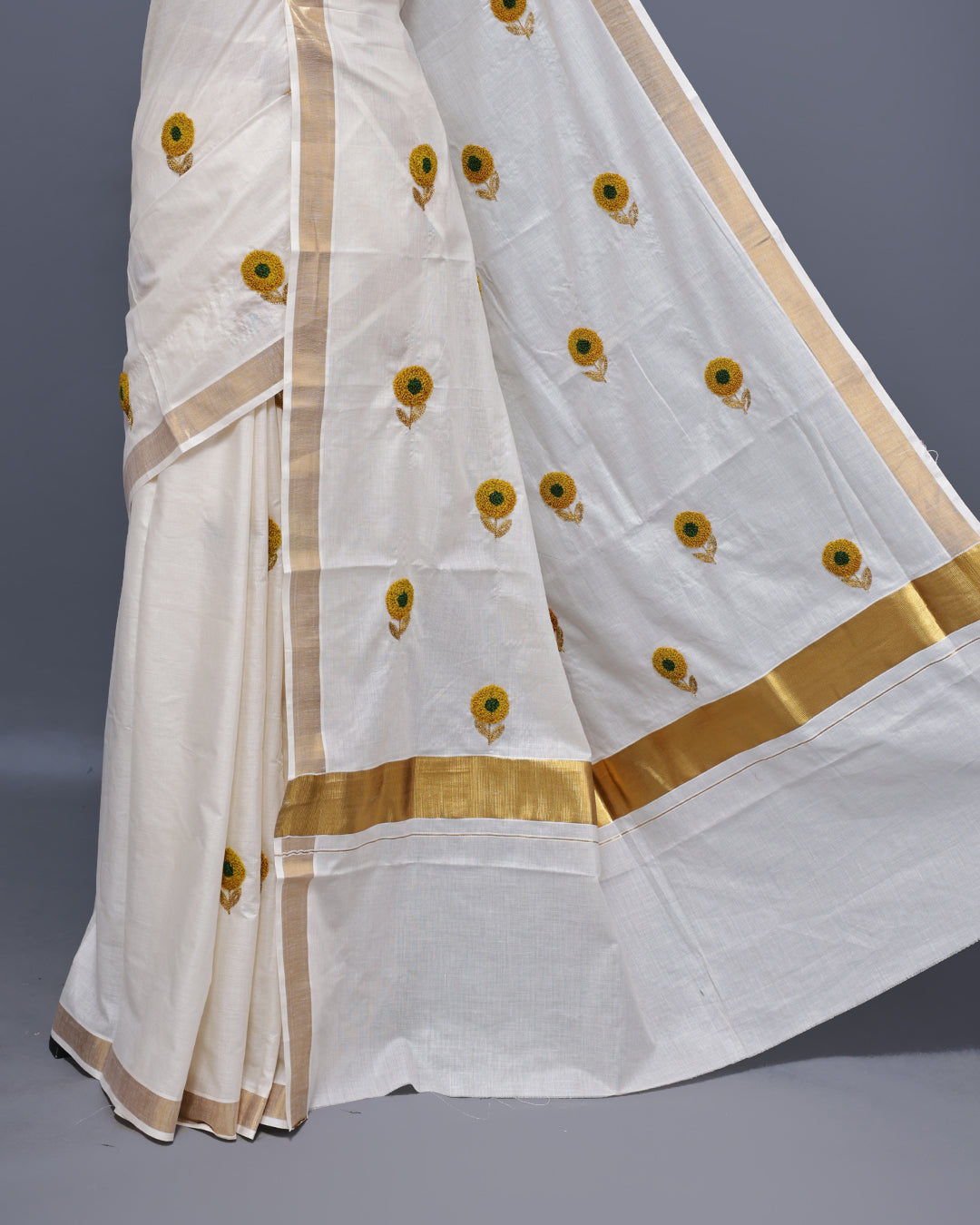 Cream colour Cotton kerala saree featuring Sunflower Embroidery work on the body, complemented by a gold zari Border, paired with a matching blouse piece.
