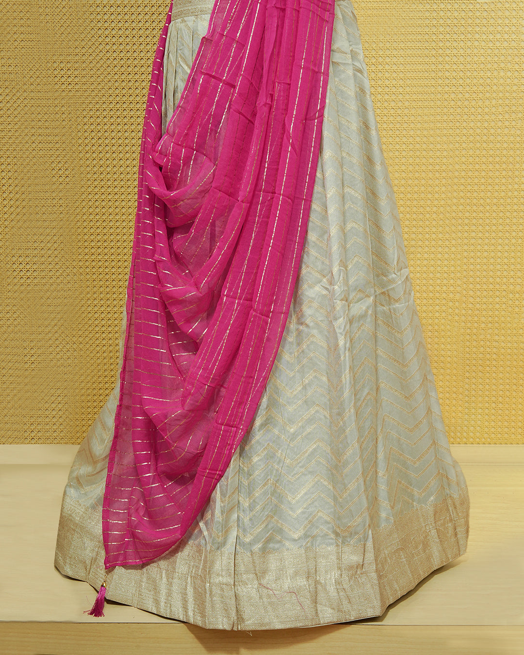 Cream colour Semi Stitched Dhavani set Featuring Gold zari Zigzag pattern With Traditional border skirt, Contrast Pink colour Dupatta, Matching blouse piece.