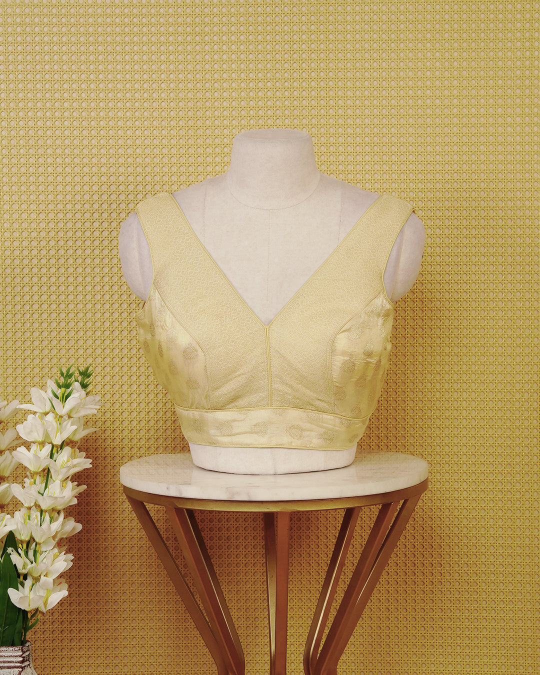 Gold colour Sleeveless Blouse Featuring A Stylish V-Neck, Elegant Woven Pattern With Gold Butta Motifs, And A Comfortable Tailored Fit.