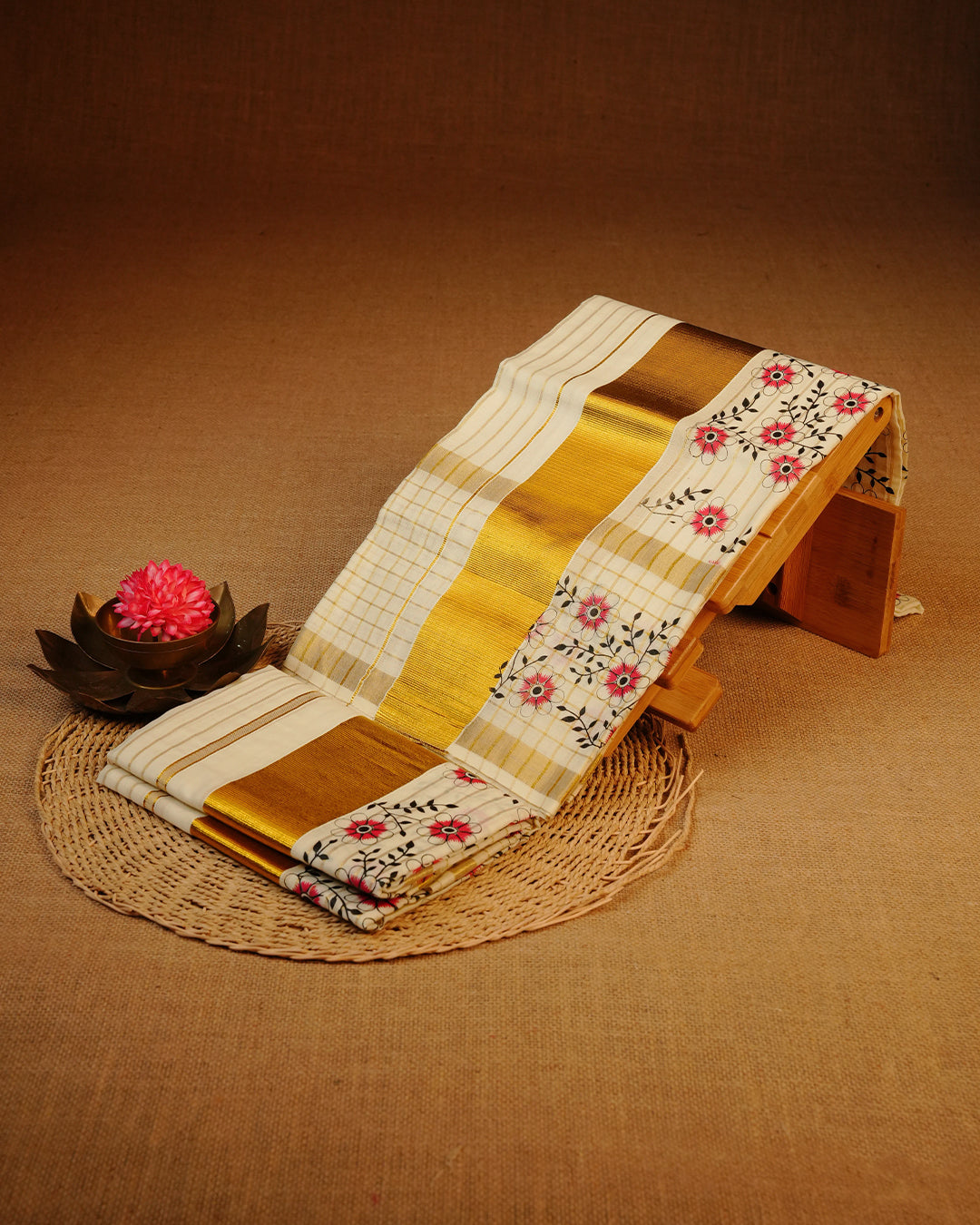 Cream colour cotton Set Mundu With Gold Zari stripes on body, enhanced with gold Kasav With Red Floral Printed kara.