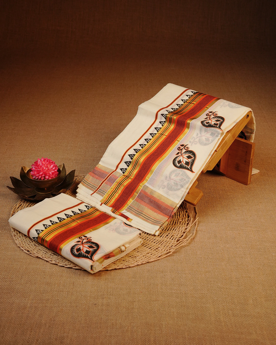 Cream colour cotton set mundu Featuring Elegant plain body, complemented by gold zari & red with Leaf print kara.