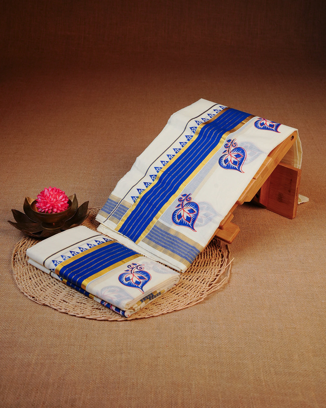 Cream colour cotton set mundu Featuring Elegant plain body, complemented by gold zari & Blue with Leaf print kara.