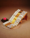 Cream colour Cotton set mundu features a Strip on body accented by a Gold with Orange Floral pattern on border.
