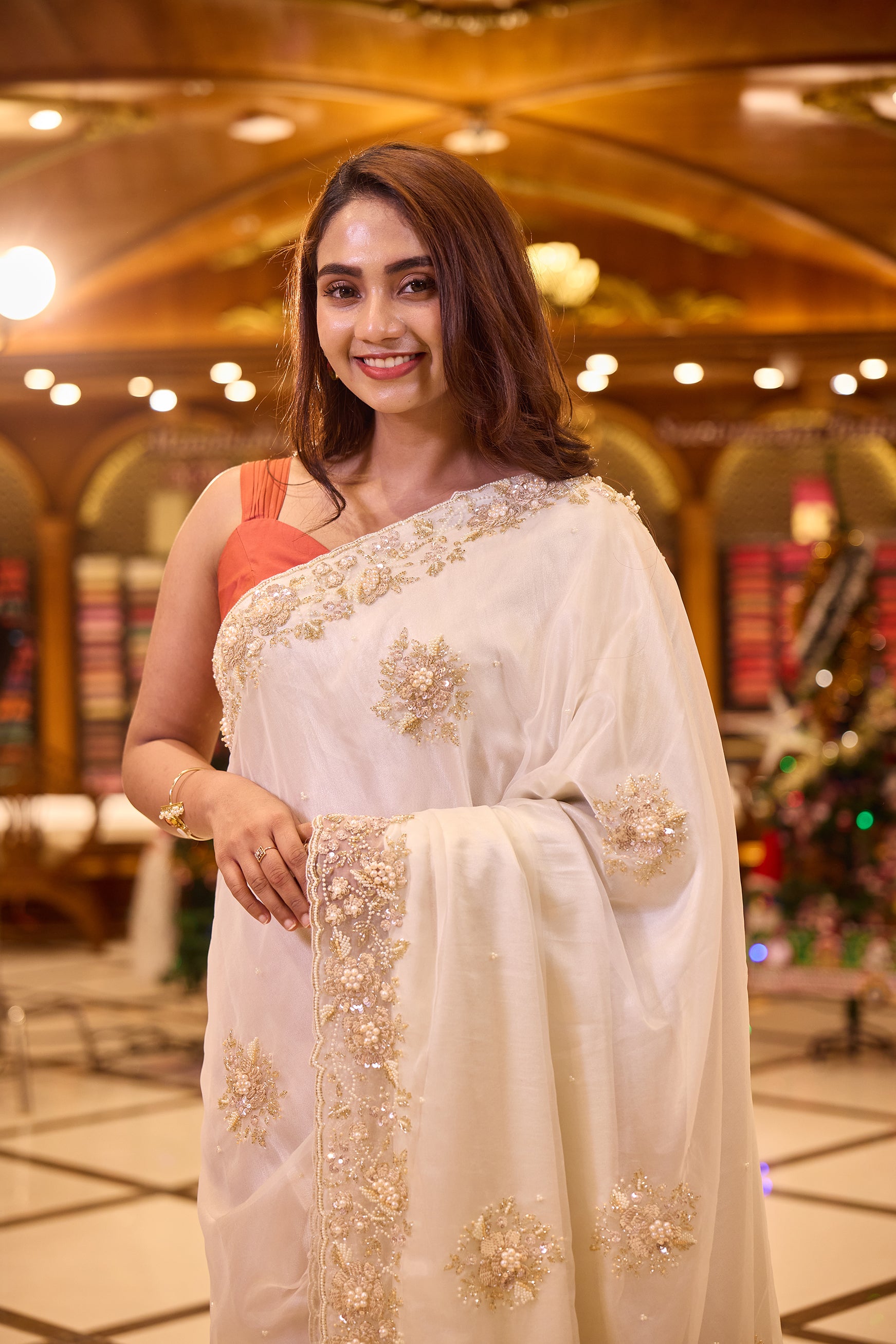 Ivory colour Pure Organza designer saree beautifully detailed with hand embroidered bead, pearl and sequin floral motifs, finished with a rich embellished border, paired perfectly with a matching designer blouse.
