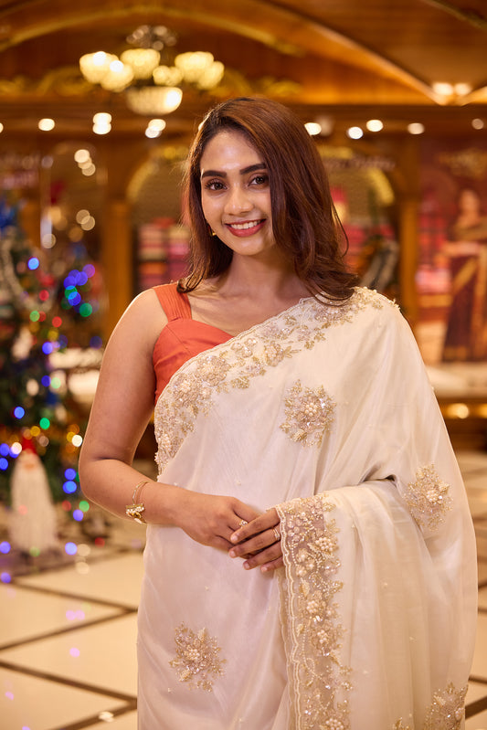 Ivory colour Pure Organza designer saree beautifully detailed with hand embroidered bead, pearl and sequin floral motifs, finished with a rich embellished border, paired perfectly with a matching designer blouse.