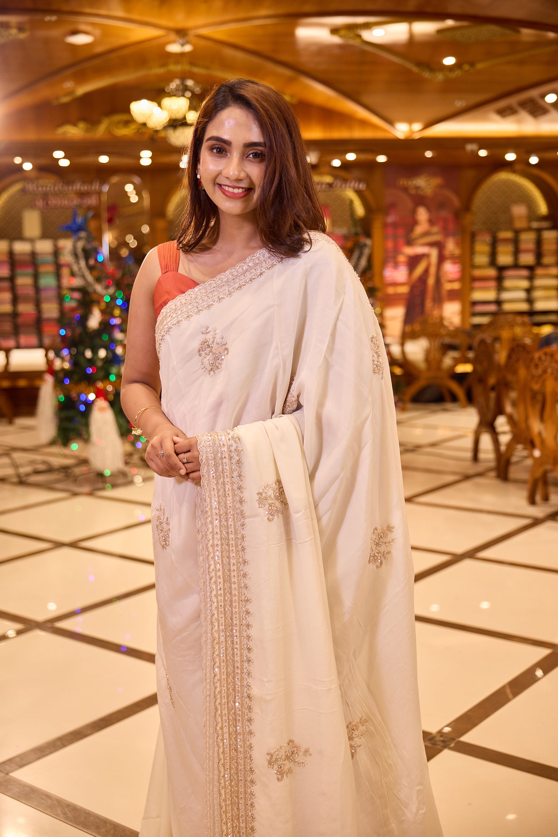 Cream colour pure organza saree with elegant hand embroidery featuring beads, sequins, pearls and thread detailing all over the body, finished with a beautifully crafted scallop border, paired with a matching worked blouse.