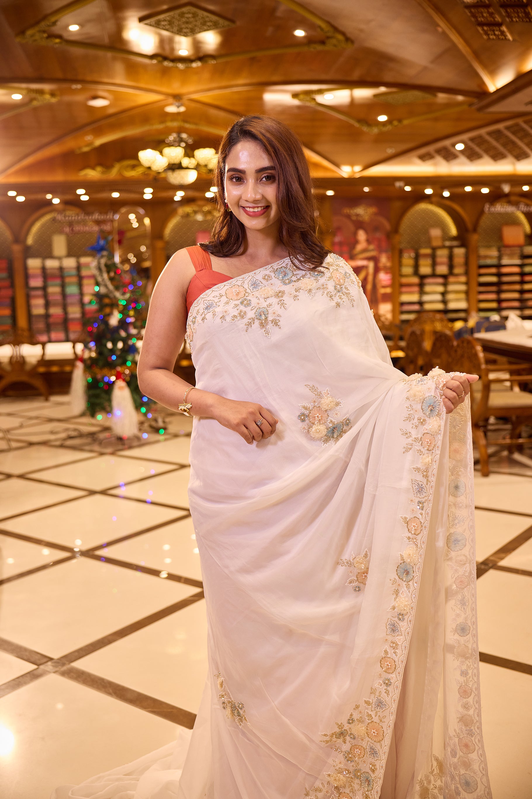 White colour Pure Organza designer saree adorned with pastel floral bead, pearl and sequin embroidery, finished with a richly embellished border, paired beautifully with a matching designer blouse