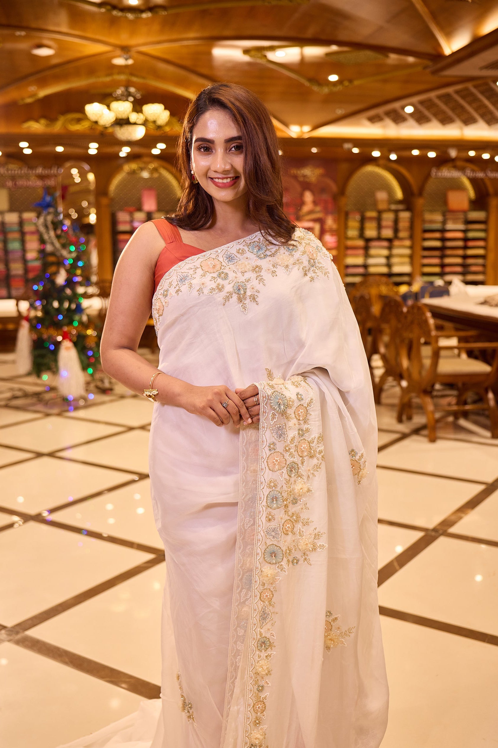 White colour Pure Organza designer saree adorned with pastel floral bead, pearl and sequin embroidery, finished with a richly embellished border, paired beautifully with a matching designer blouse