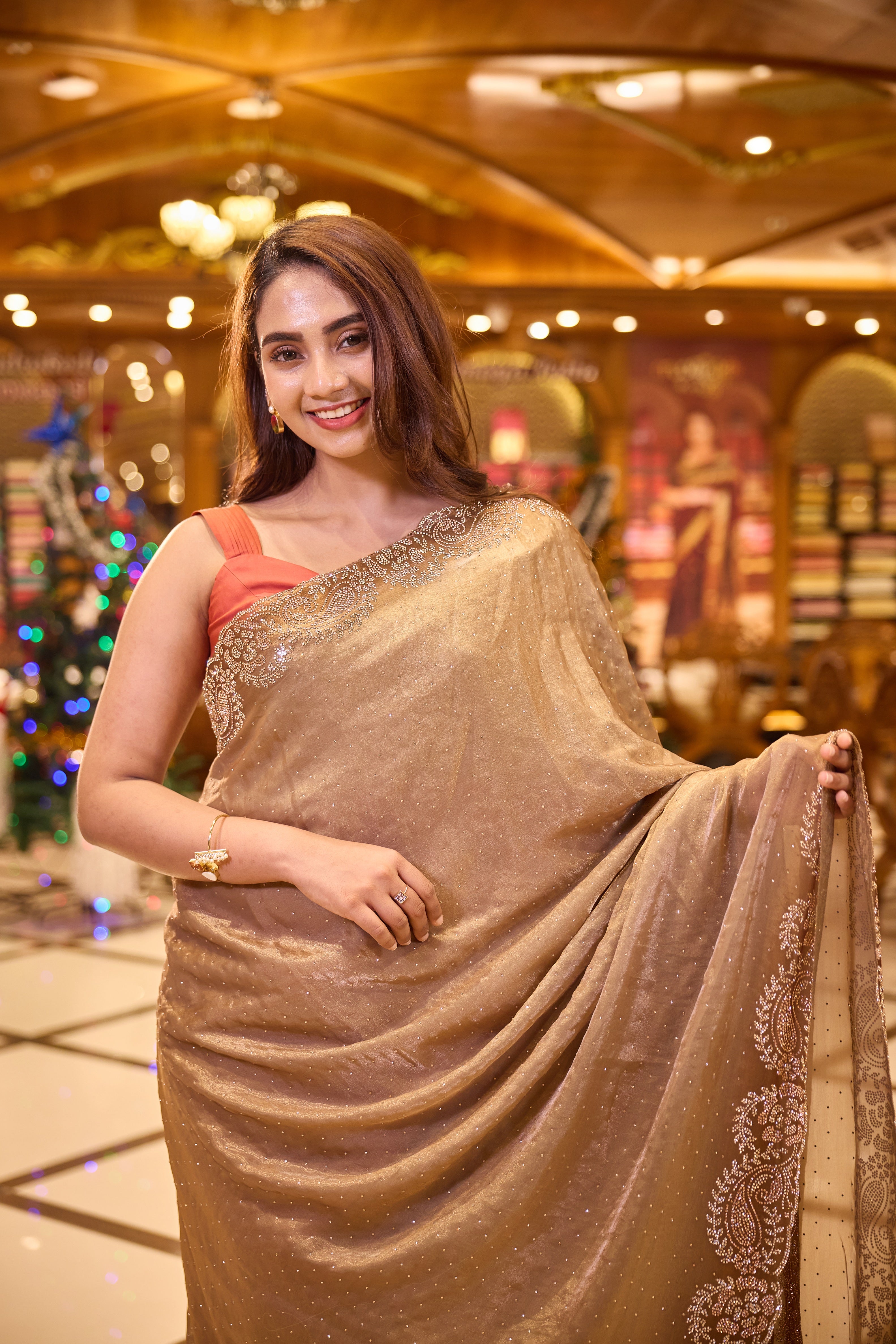 Rich antique gold colour Shimmer tissue coated saree, adorned with Swarovski crystal work and finished with a beautiful contrast scallop border, paired with a matching worked blouse