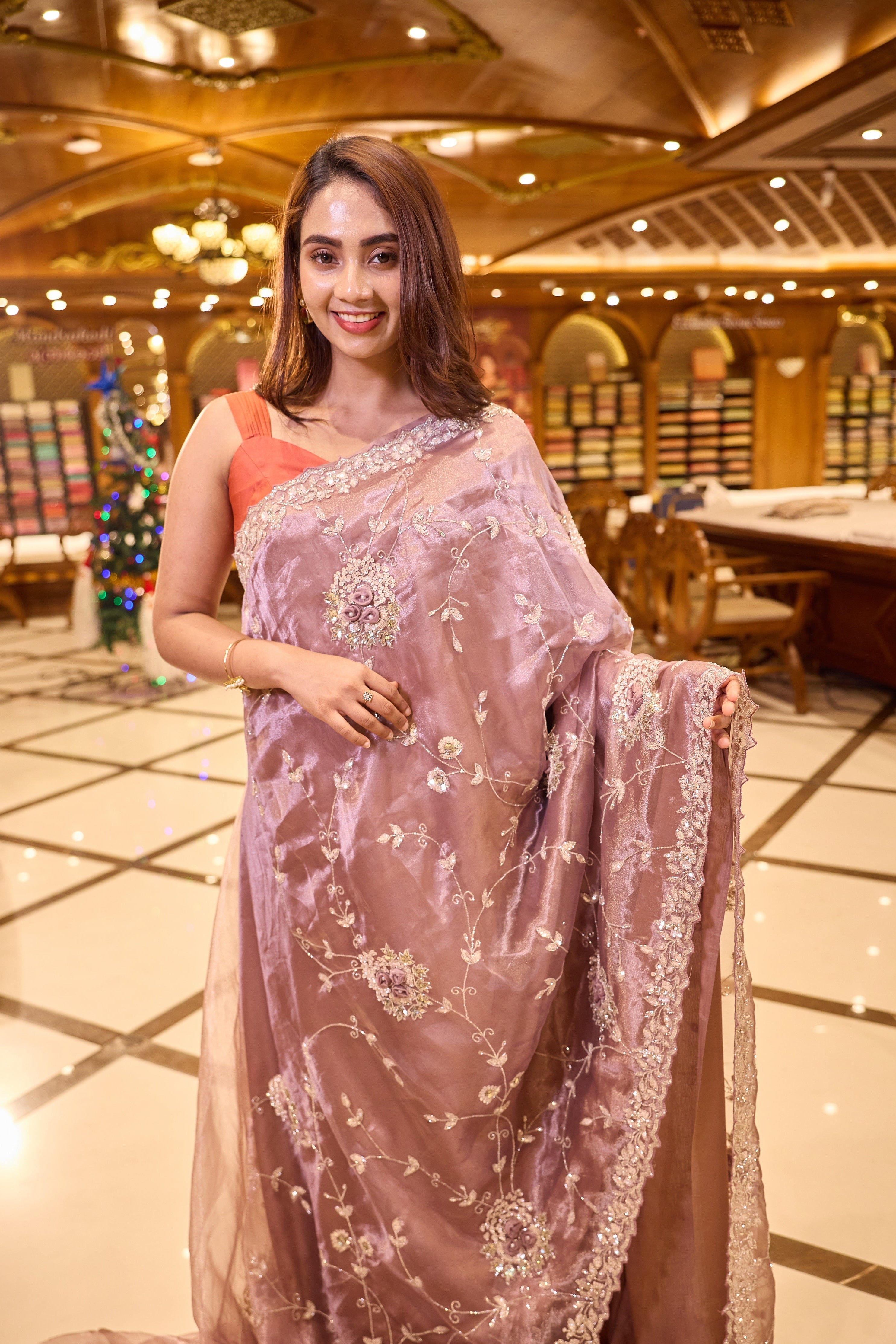 Mauve colour Tissue Organza saree with exquisite hand embroidery Floral work all over the body and a beautifully finished scallop border, paired with a matching worked blouse.