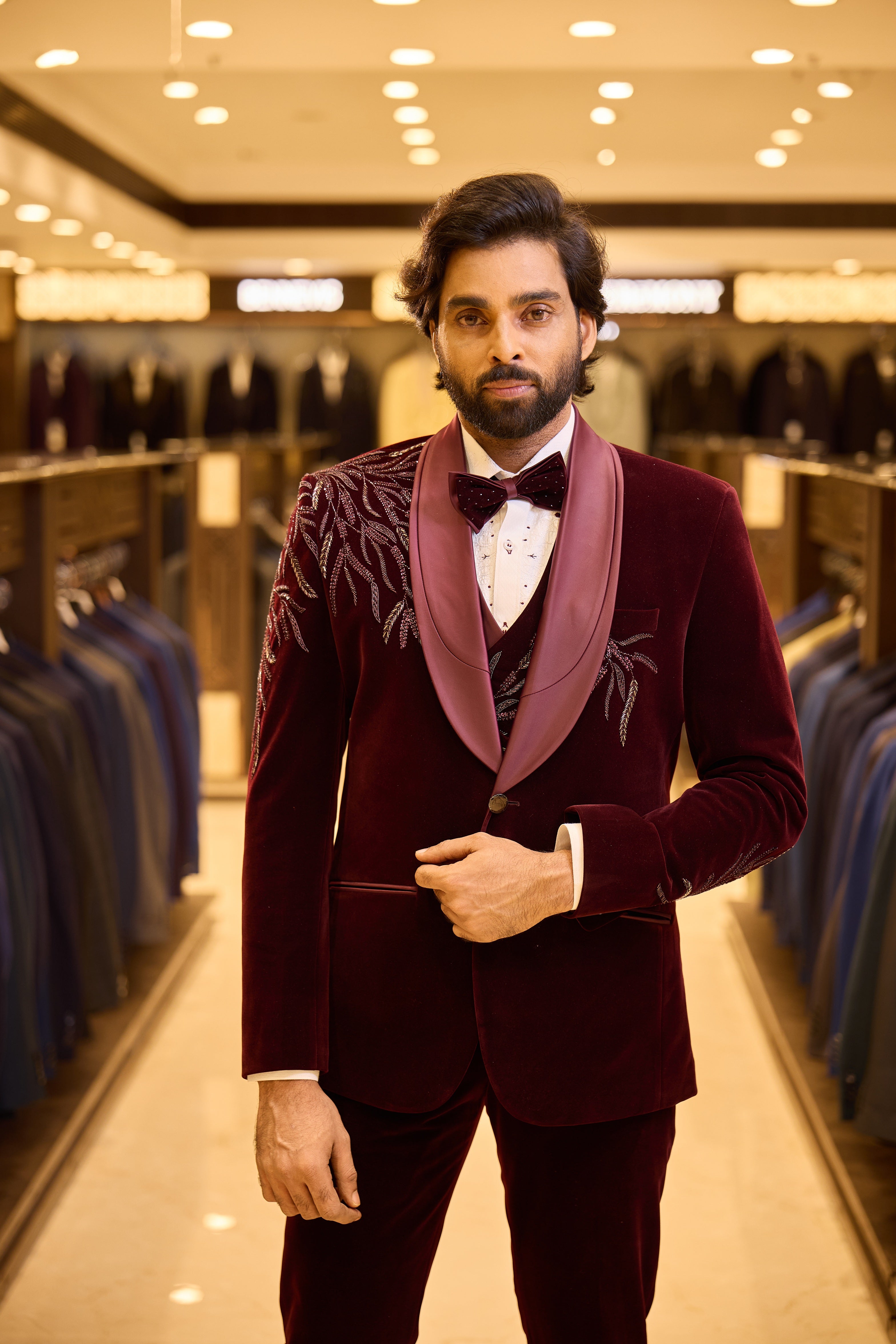Rich maroon two tone velvet groom wear by BENNIVES, elevated with special stone work and a stylish neck d’xesto lapel for an elegant, luxurious wedding look.