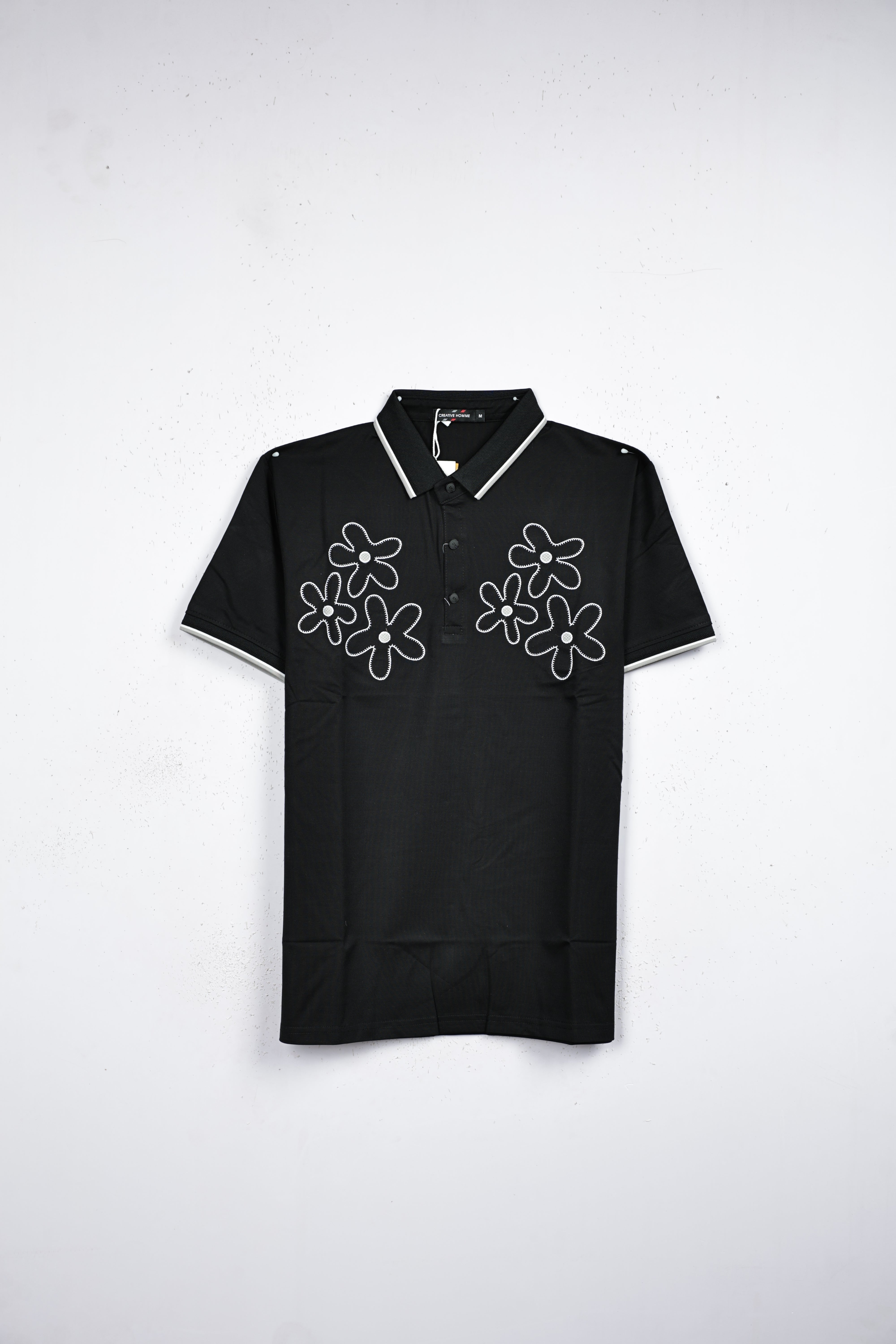 Black colour T shirt featuring white thread pattern on body, collar design neck, Half sleeve.